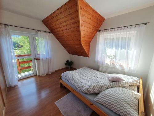 a bedroom with a bed and a large window at Zawoja 1895 sauna bania in Zawoja