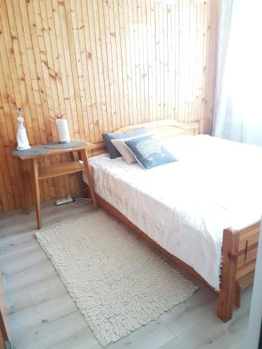 a bedroom with a bed and a table with a book at Kaimo apartamentai! in Budraičiai