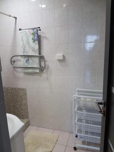 uma casa de banho com um chuveiro, um WC e uma toalha em Kaimo apartamentai! em Budraičiai