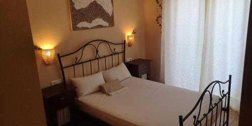 a bedroom with a bed with white sheets and a window at Mas Pinell 129 in Torroella de Montgrí