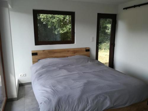 1 dormitorio con 1 cama grande y ventana en Chalet du dry la roche., en Vielsalm