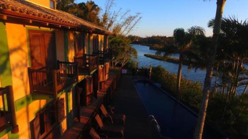 a building with a view of a river and a house at Pousada Engenho da Lagoa in Garopaba