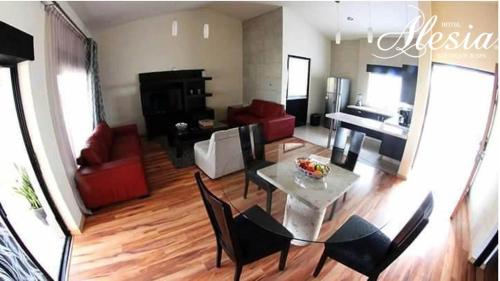 a living room with a table and chairs and a piano at Alesia - Boutique Hotel & Spa in Aguascalientes