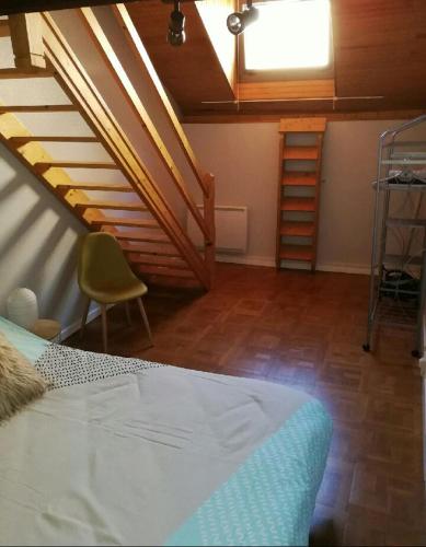 une chambre avec un escalier et un lit dans une chambre dans l'établissement La Citadine maison de ville avec garage, à Bagnères-de-Bigorre