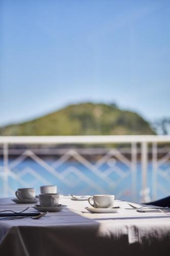a table with two cups and saucers on it at Hotel Silken Palacio Uribarren in Lekeitio