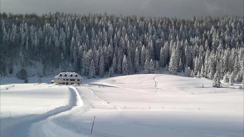 a house in the middle of a snow covered field at Maison de la Combe des Cives in Chapelle-des-Bois