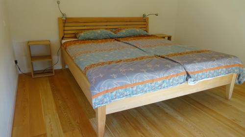 a bedroom with a bed with a wooden headboard at Arwen in Uhldingen-Mühlhofen