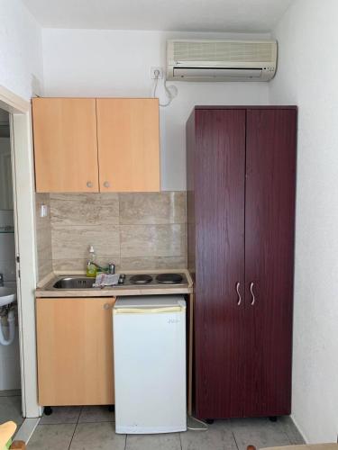 a small kitchen with a stove and a refrigerator at Jelić apartmani in Sutomore