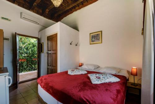 a bedroom with a bed with red sheets and a window at Kristina´s rooms in Rhodes Town