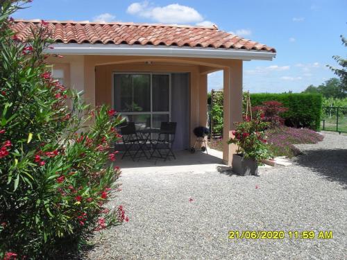 une maison avec un patio avec une table et des chaises dans l'établissement maisonnette neuve à la campagne, à Urgosse