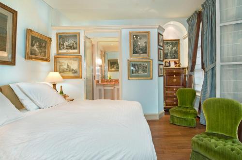 - une chambre avec un lit et deux chaises vertes dans l'établissement Luxury, Calm and Elegance in the heart of Champs-Elysées with a bottle of Champagne upon your arrival !!!, à Paris
