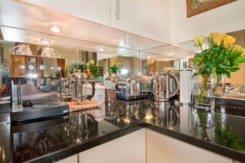- une cuisine avec un comptoir et de nombreux appareils dans l'établissement Luxury, Calm and Elegance in the heart of Champs-Elysées with a bottle of Champagne upon your arrival !!!, à Paris