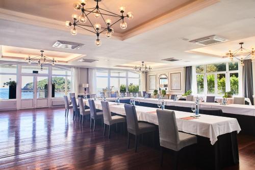 a dining room with a long table and chairs at Hotel Silken Palacio Uribarren in Lekeitio
