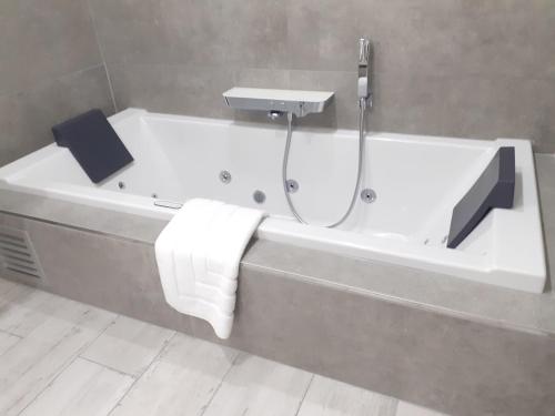 a bathroom with a bath tub with a sink at Villa Blue Garden B&B Vlaamse Ardennen nabij Pairi Daiza in Geraardsbergen