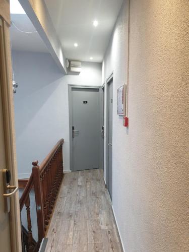 a hallway with a door and a wooden floor at Hôtel Belfort in Montreuil