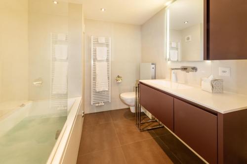 a bathroom with a toilet and a sink and a tub at Ferienwohnung Haus Mia in Zermatt