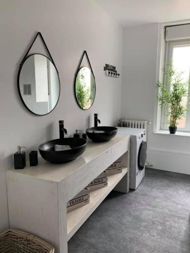 La salle de bains est pourvue de 2 lavabos et d'un miroir mural. dans l'établissement La Felicità classement ****vue Cathédrale!, à Boulogne-sur-Mer