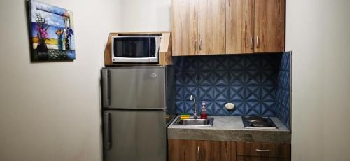 cocina con microondas y nevera en Apartamento mediano ideal para parejas o ejecutivos, en Manta