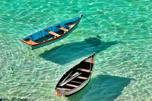 two boats floating in the water in the ocean at Mar aberto suítes in Arraial do Cabo