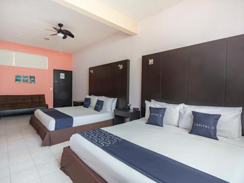 Habitación de hotel con 2 camas y sofá en Hotel Spa Shalam en Coatepec