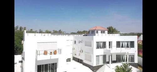 an image of a white building at Appartement Luxueux En Résidence vu sur mer à 50 mètres de la plage in Sali Tapé