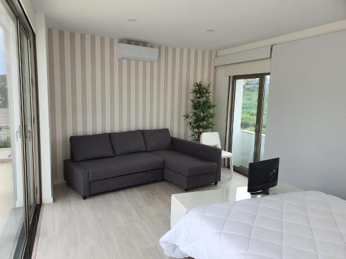 salon z łóżkiem i kanapą w obiekcie Figueira Beach Apartment w mieście Buarcos