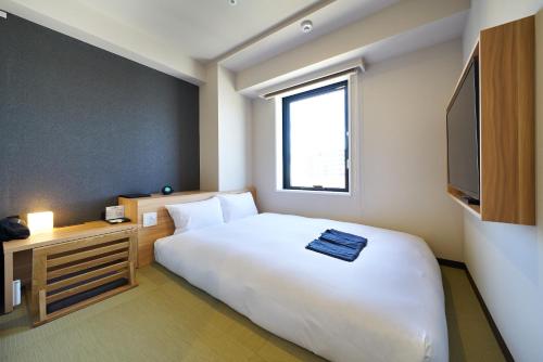 a hotel room with a large bed and a television at HOTEL Enmichi in Kawasaki