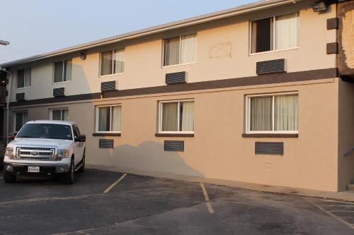 a white truck parked in a parking lot in front of a building at Wyatt Earp Hotel in Dodge City