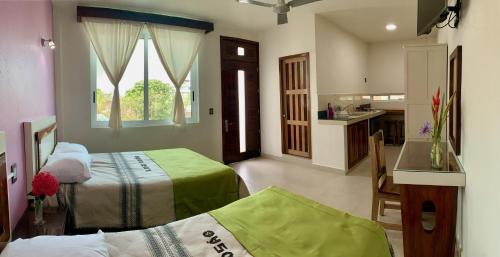 um quarto de hotel com duas camas e uma cozinha em Lidxi Rosae em Puerto Escondido
