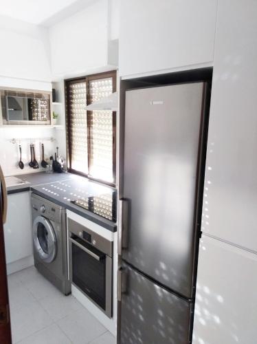 a kitchen with a refrigerator and a washer and dryer at los pisitos de El Barraco 2 in El Barraco