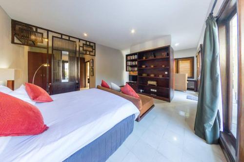 een grote slaapkamer met een groot wit bed met rode kussens bij Villa Simone Bali in Ungasan