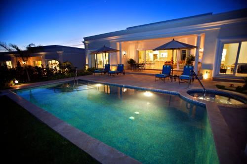 a swimming pool in front of a house at night at Pueblo Bonito Emerald Luxury Villas & Spa All Inclusive in Mazatlán