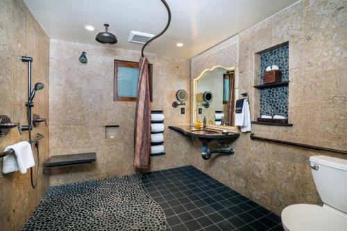 a bathroom with a shower and a toilet and a sink at Pantai Inn in San Diego