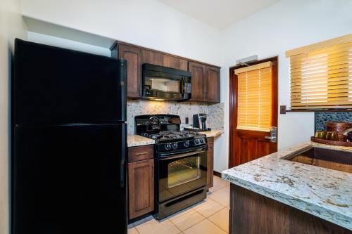 a kitchen with a black refrigerator and a stove at Pantai Inn in San Diego