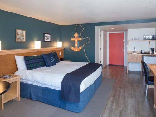 a bedroom with a large bed and a kitchen at Surftides Hotel in Lincoln City