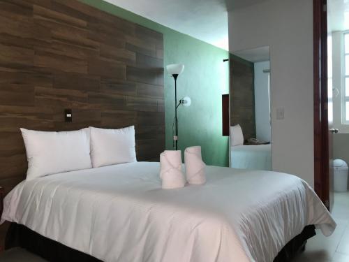 a bedroom with a white bed with white pillows at Malinalli Express in Apizaco