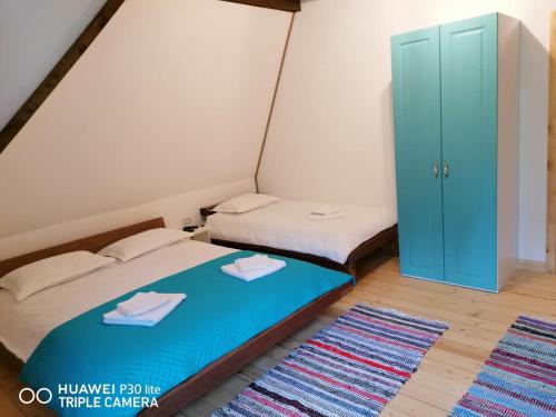 Habitación pequeña con 2 camas y armario azul en Cabana Agroturistica Runc en Borşa
