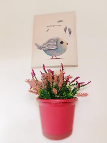 a red pot with a bird picture and a plant at SmallFry's Beach Resort in Calatrava