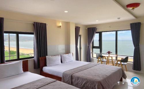 a hotel room with two beds and a view of the ocean at Thiên Hải 2 Hotel in Quy Nhon