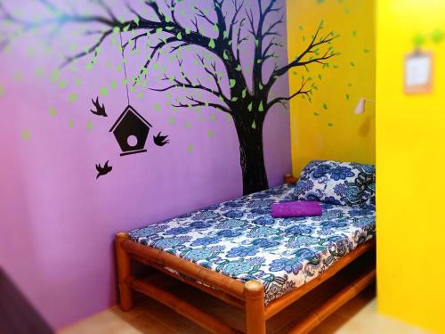 a bedroom with a tree with birds and a bird house at SmallFry's Beach Resort in Calatrava