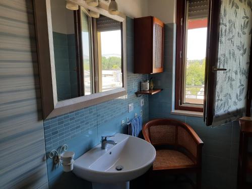 a bathroom with a sink and two windows at casa Lorena in Frosinone