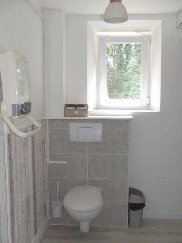 ein Bad mit einem WC und einem Fenster in der Unterkunft Gîte les Hortensias in Beauquesne