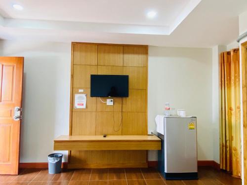 a room with a refrigerator and a tv on a wall at Metha Palace in Sakon Nakhon