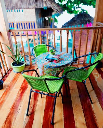 two green chairs and a table on a deck at SmallFry's Beach Resort in Calatrava