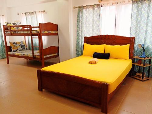 a bedroom with a large bed with a yellow bedspread at SmallFry's Beach Resort in Calatrava