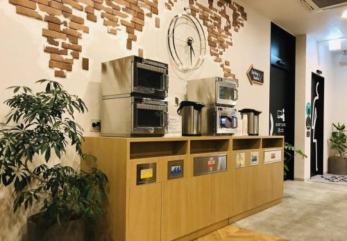 a store with two microwaves on top of a counter at eeGee STAY Omiya in Saitama