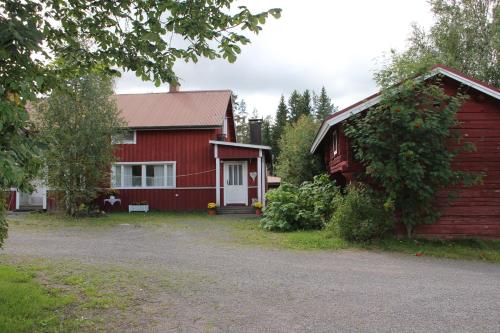 a red house next to a red barn at Yö Kotikoivun rauhassa in Kankaanpää