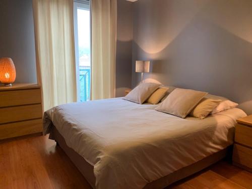 a large bed in a bedroom with a window at Appartement Standing 55m2 - Terrasse Sud, Parking, Wifi in Aix-les-Bains