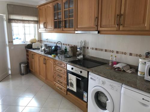 a kitchen with a washer and a washing machine at Villa Lota in Vila Nova De Cacela