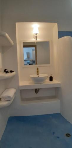 a white bathroom with a sink and a mirror at Bella Vista in Panteli